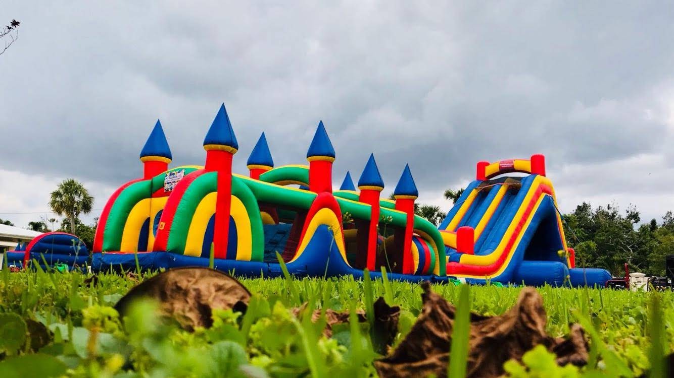 Colorful inflatable obstacle course and slide set up outdoors in South Florida